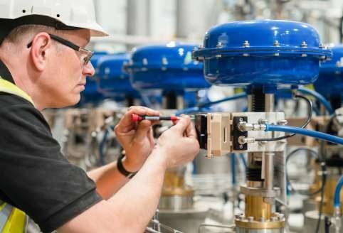 Specialist technician performing control valve maintenance and calibration